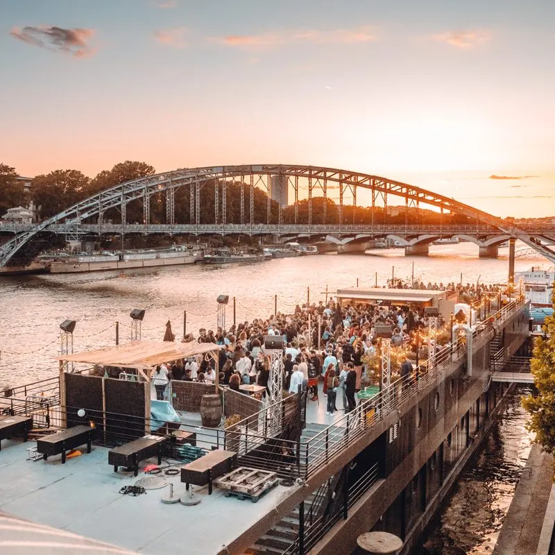 La péniche pleine au coucher du soleil, devant le pont